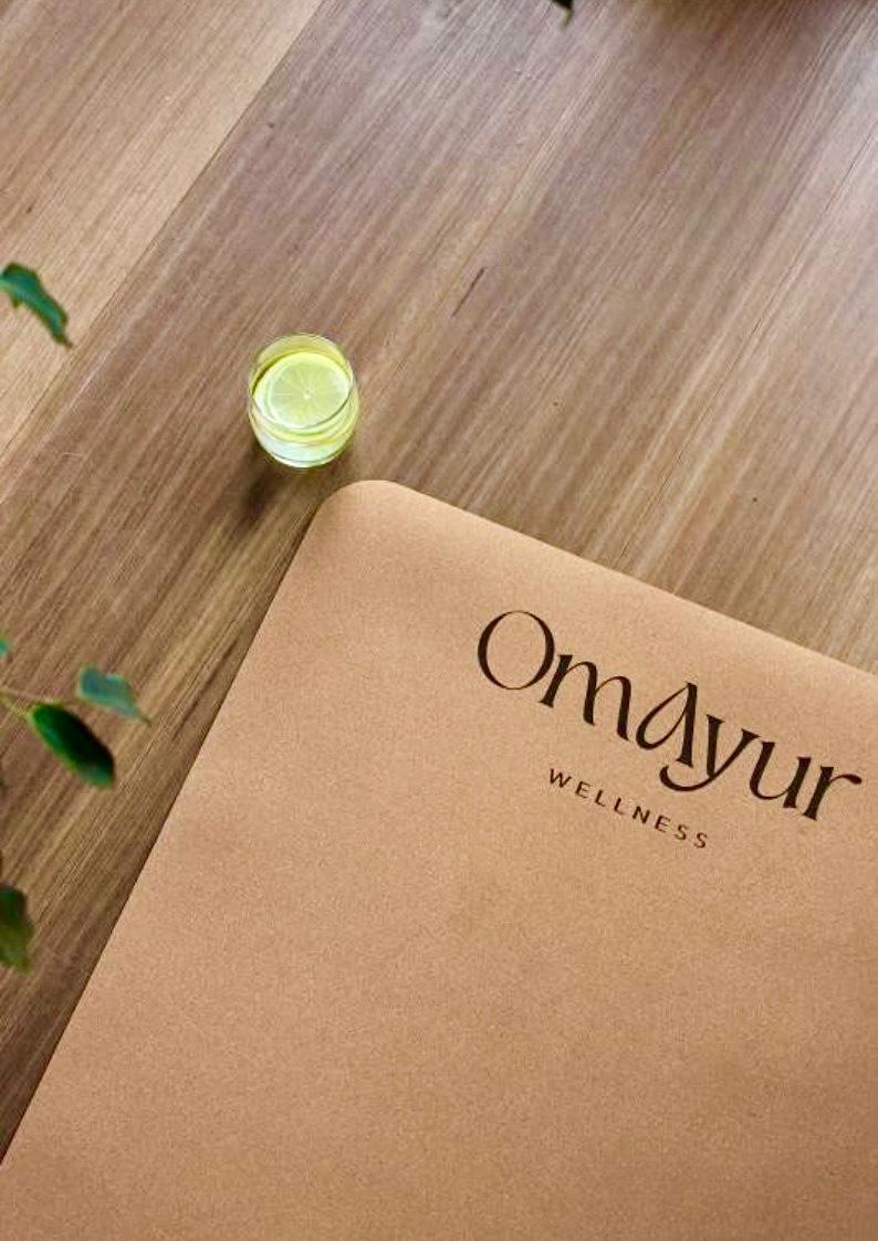 OmAyur wellness yoga mat, natural rubber cork-style surface with logo