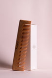 Brown hair comb with fine teeth, shown with white product box