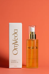 OmVeda calming body oil, amber bottle with pump and matching carton box