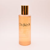 OmVeda clarifying solution 100ml translucent amber bottle with gold cap, front view