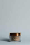 OmVeda Gentle Sesame Polish jar with gold lid, bronze tinted glass