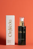 OmVeda Personal Growth Hair Oil bottle with white product box, black label