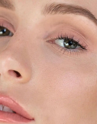 Close-up view of blue-green eye with natural-looking makeup and lashes.