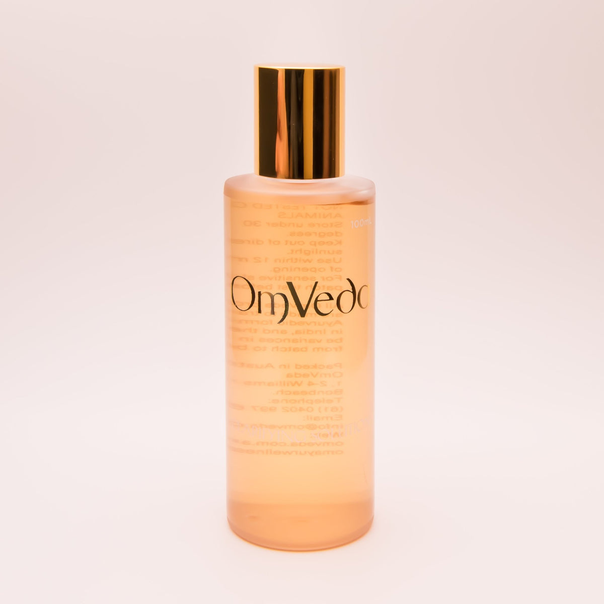 OmVeda clarifying solution 100ml translucent amber bottle with gold cap, front view