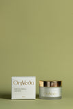 OmVeda exfoliating grains jar with gold lid, 50 ml, shown with product box
