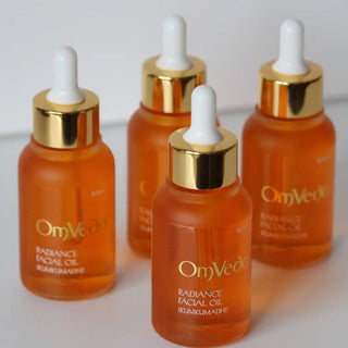 Orange glass dropper bottles with gold caps containing facial oil.