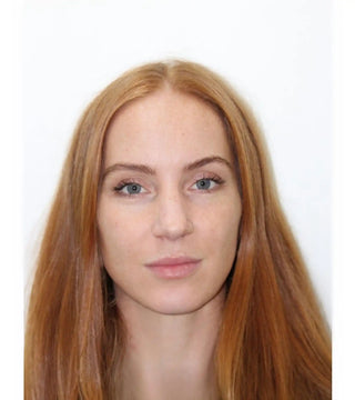 Portrait photo showing long red hair, fair skin, and natural-looking makeup.