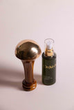 Kansa body massager and dark green massage oil bottle with gold pump top